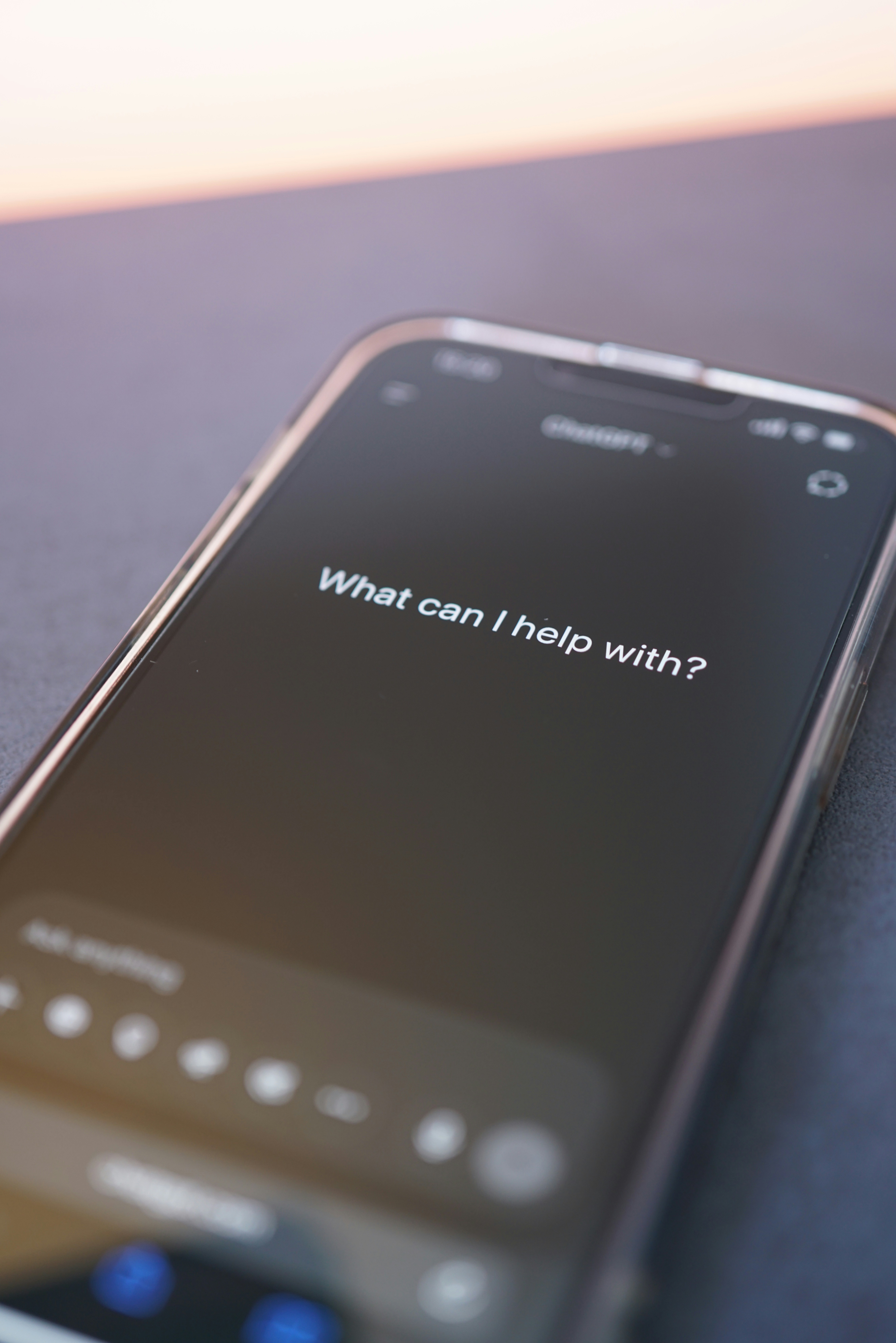 A smartphone with an AI chat prompt page open reading “What can I help with?”